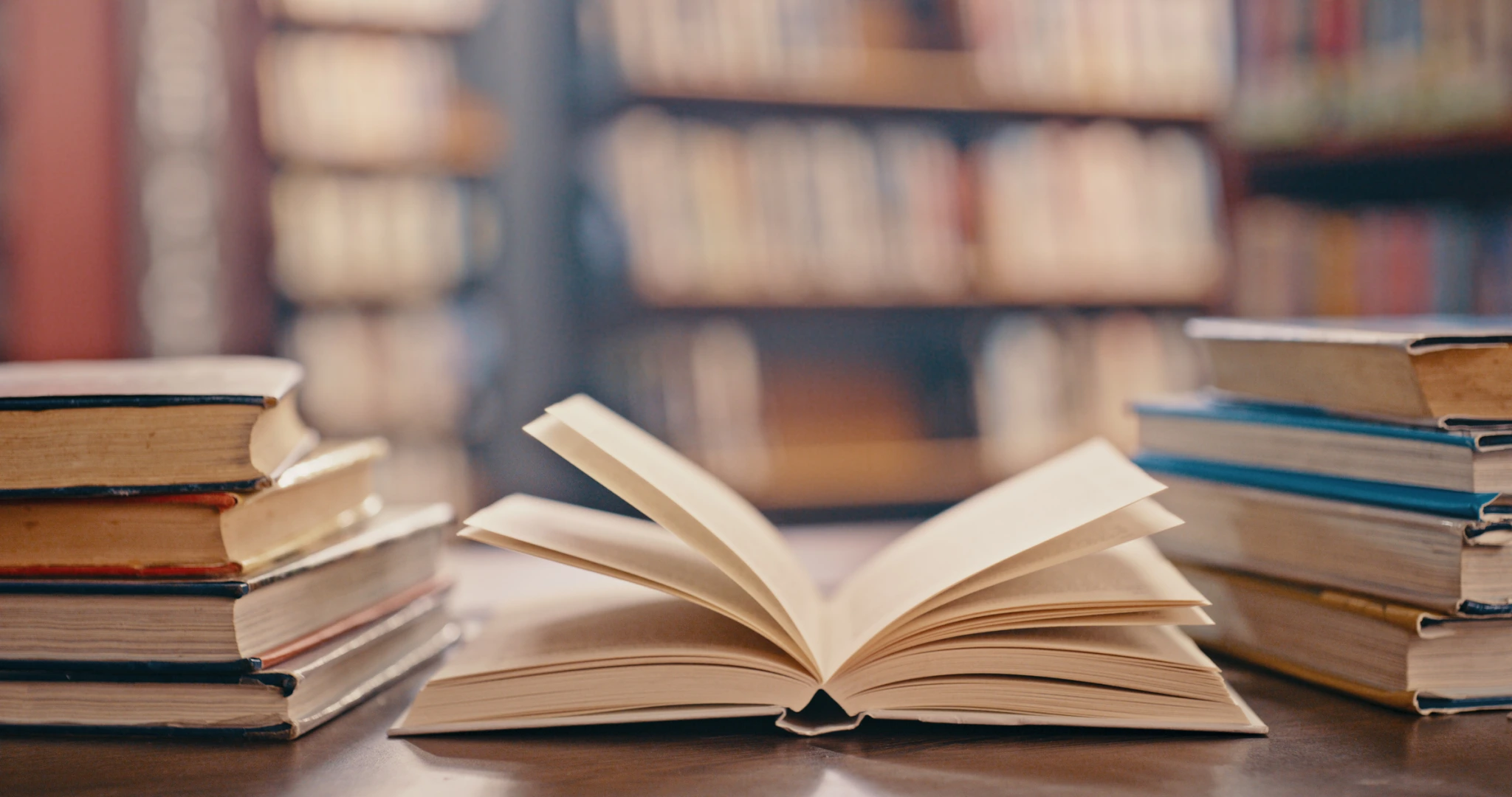 A collection of books neatly arranged on a wooden table in a library setting for storytelling b2b marketing