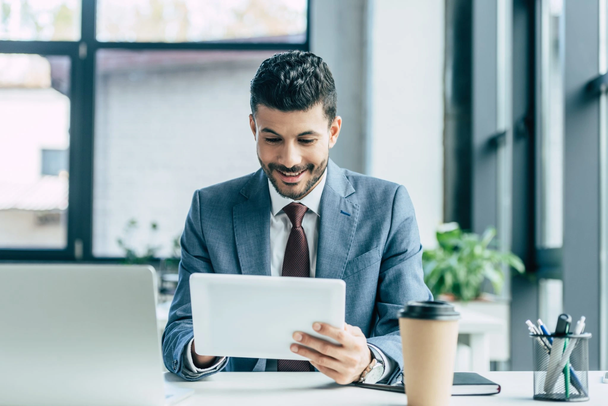 Business professional using a tablet at a desk, representing B2B content marketing strategy.