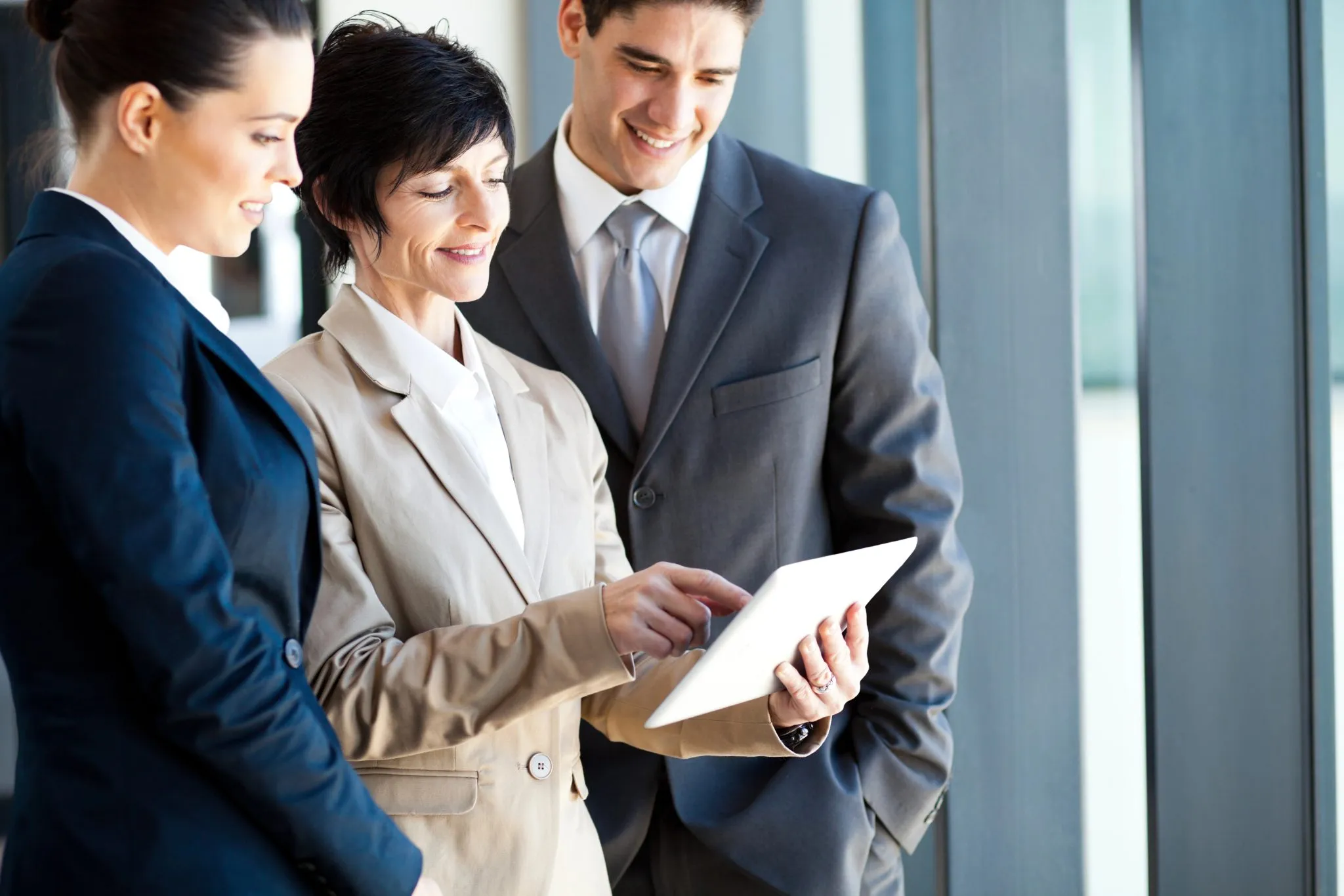 Business professionals reviewing a tablet together, representing B2B brand strategy.