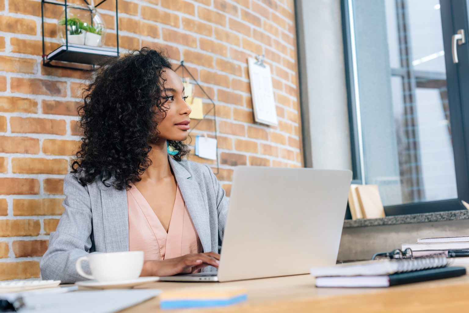 businesswoman sitting at office desk with laptop learning out the role of advocacy in business-to-business marketing