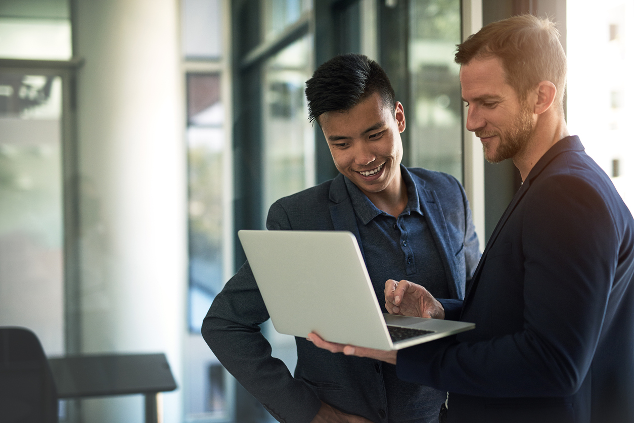 two happy businessmen work in office with computer and learn about digital marketing trends in 2024