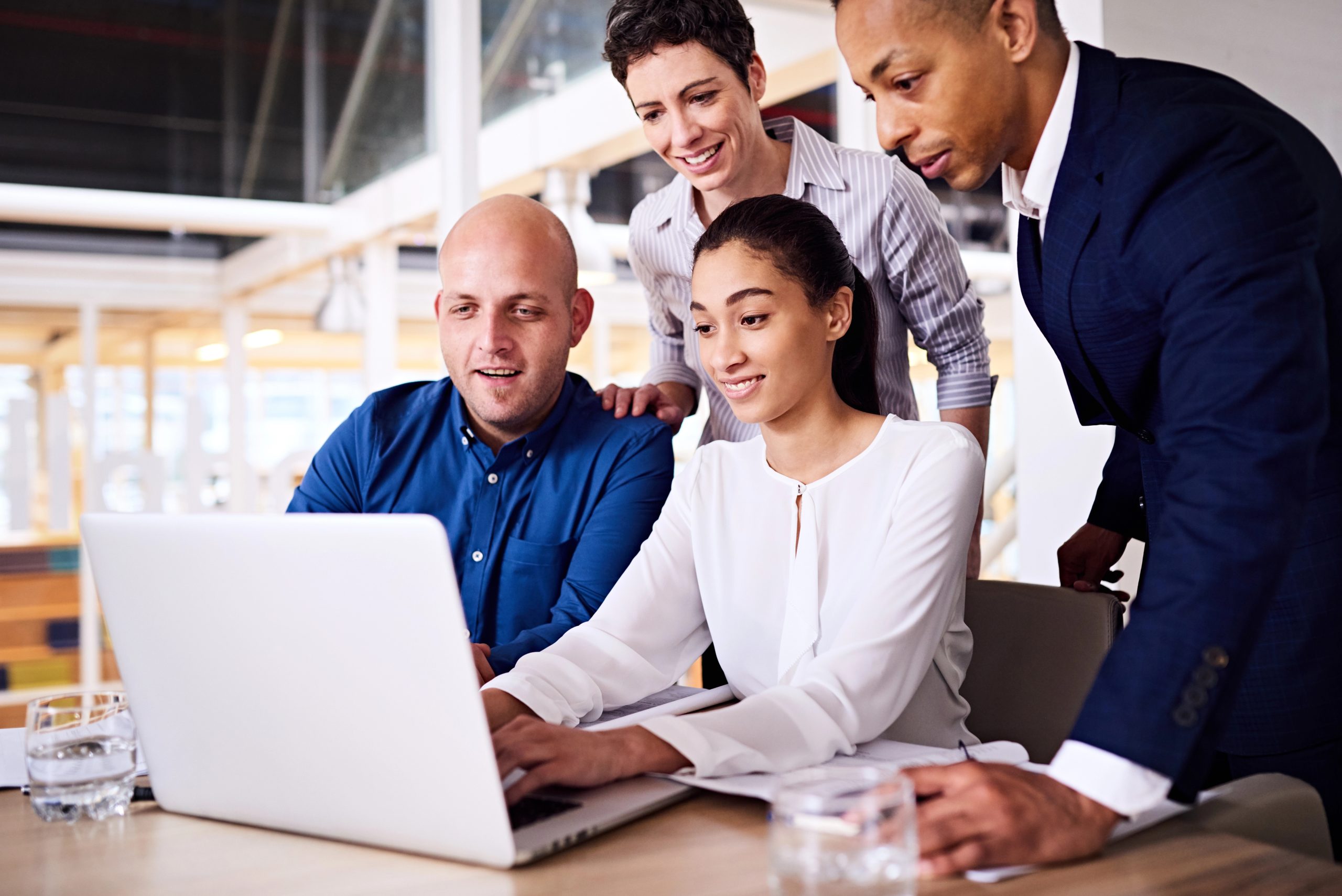 business colleagues sitting at desk with laptop computer learning about immigration and economic growth
