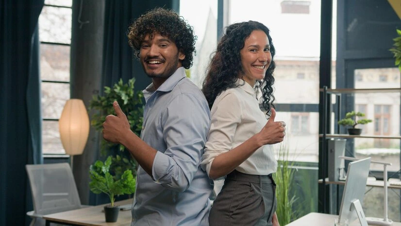 Two professionals standing back to back in an office, symbolizing successful B2B lead generation.