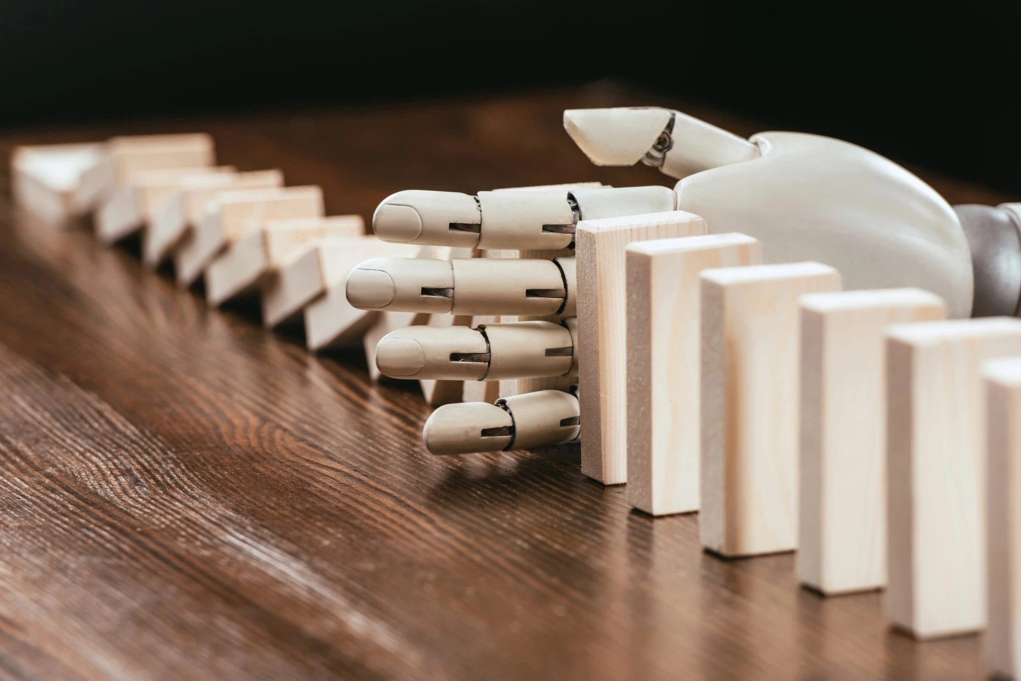 A robotic hand skillfully plays dominoes on a wooden table, showcasing precision and technology in action for seo content guidelines 2025