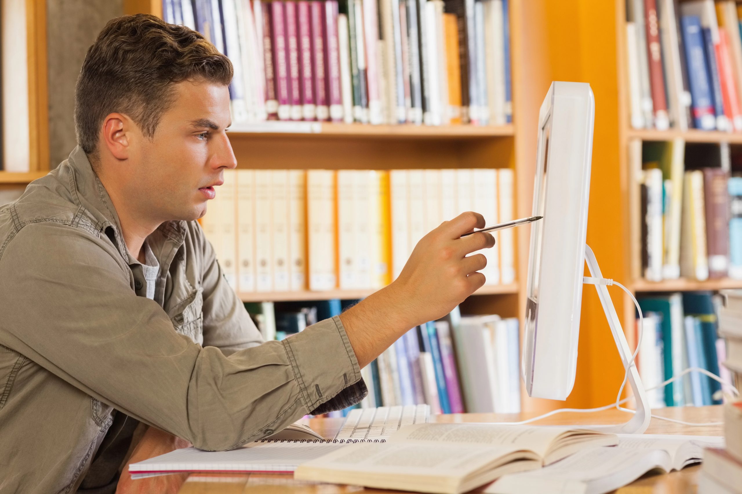 man pointing at computer screen with pen