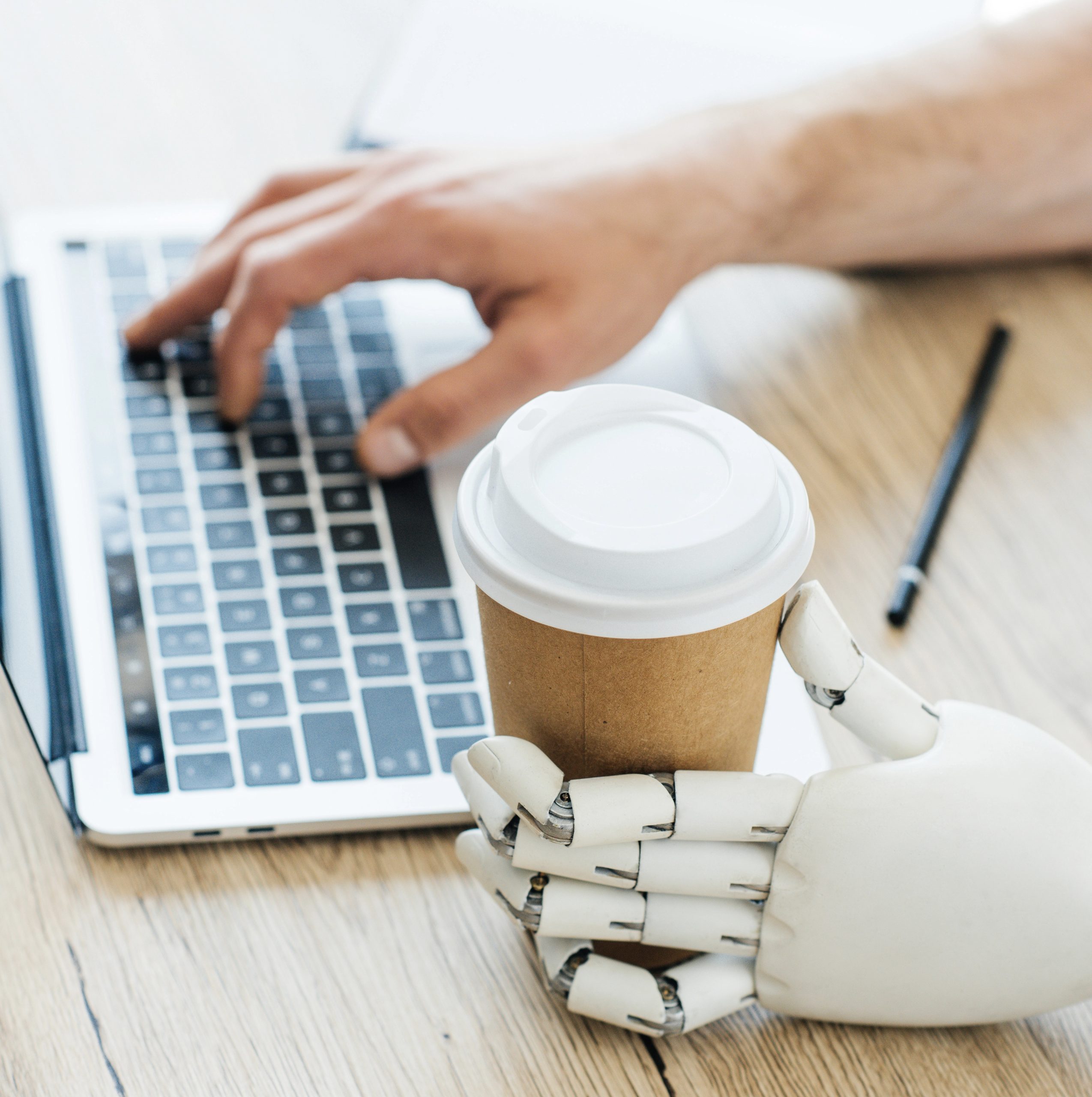 robot and human hands at computer with coffee